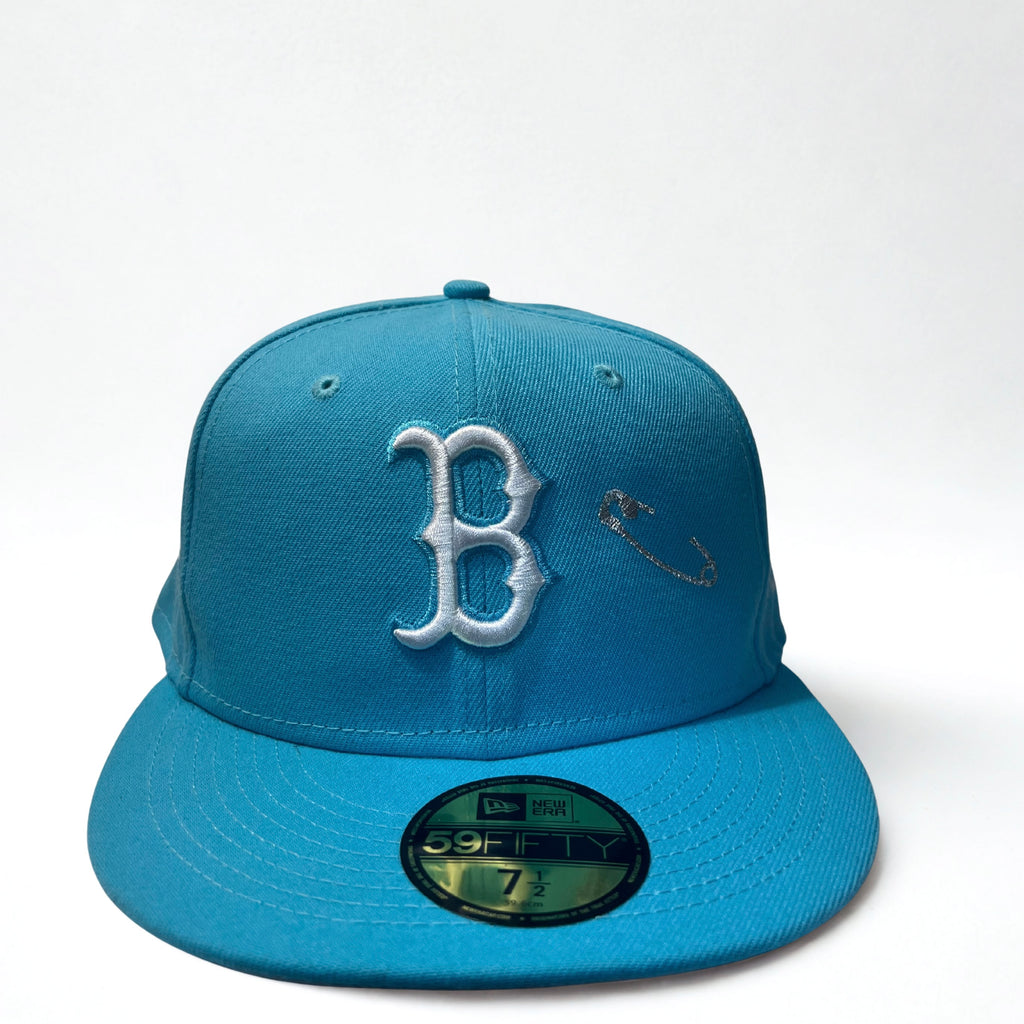 A bright blue Boston Red Sox fitted baseball cap , with silver safety pin embroidery.